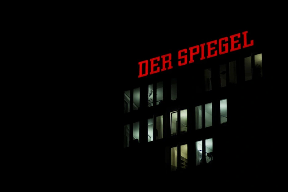 Moderno edificio per uffici con facciata in vetro che riflette il cielo.